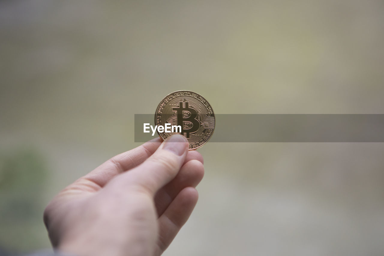 Cropped hand of person holding bitcoin