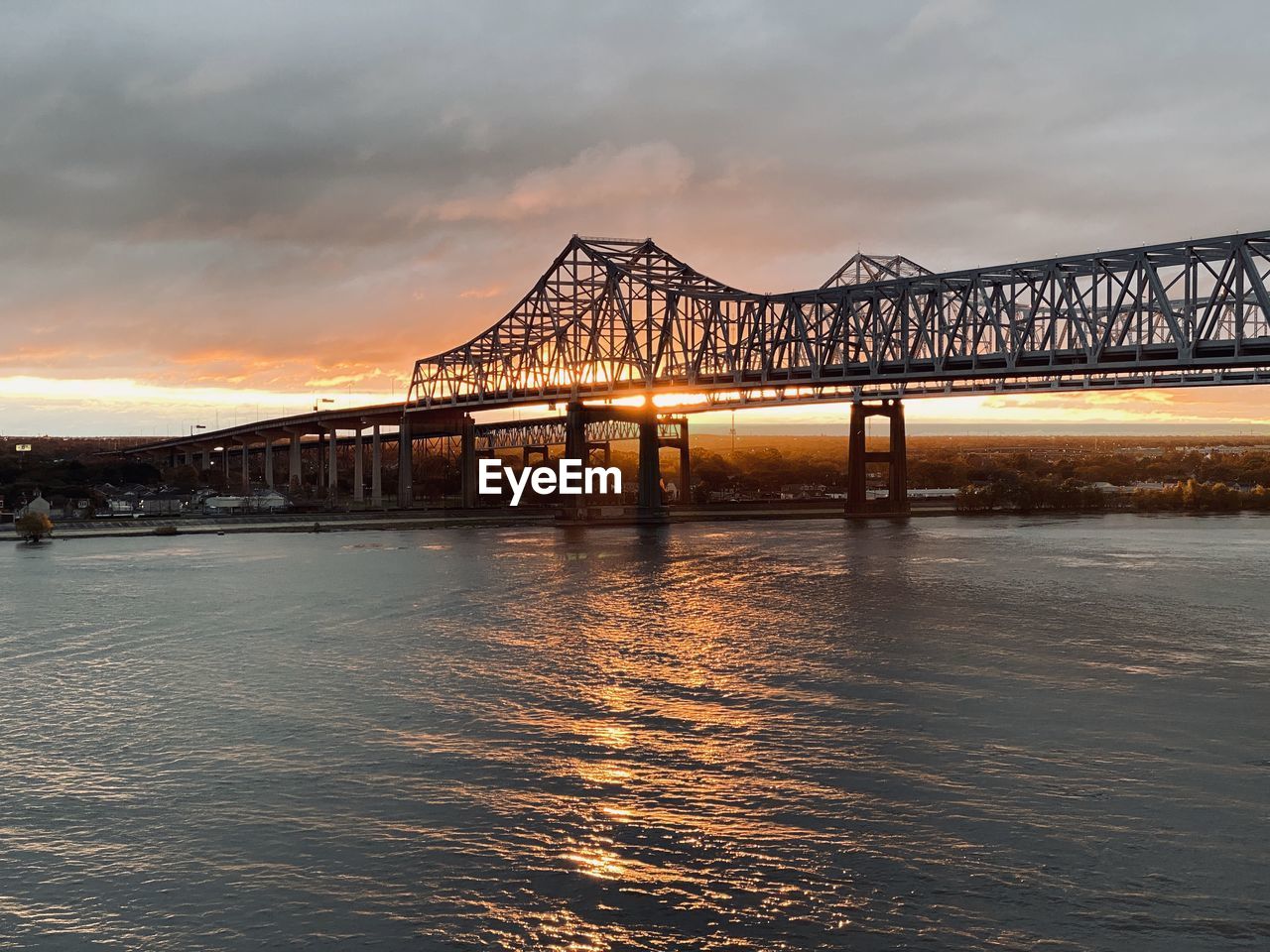 Bridge over river against sky during sunset