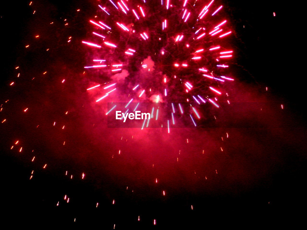 Low angle view of firework display in sky at night