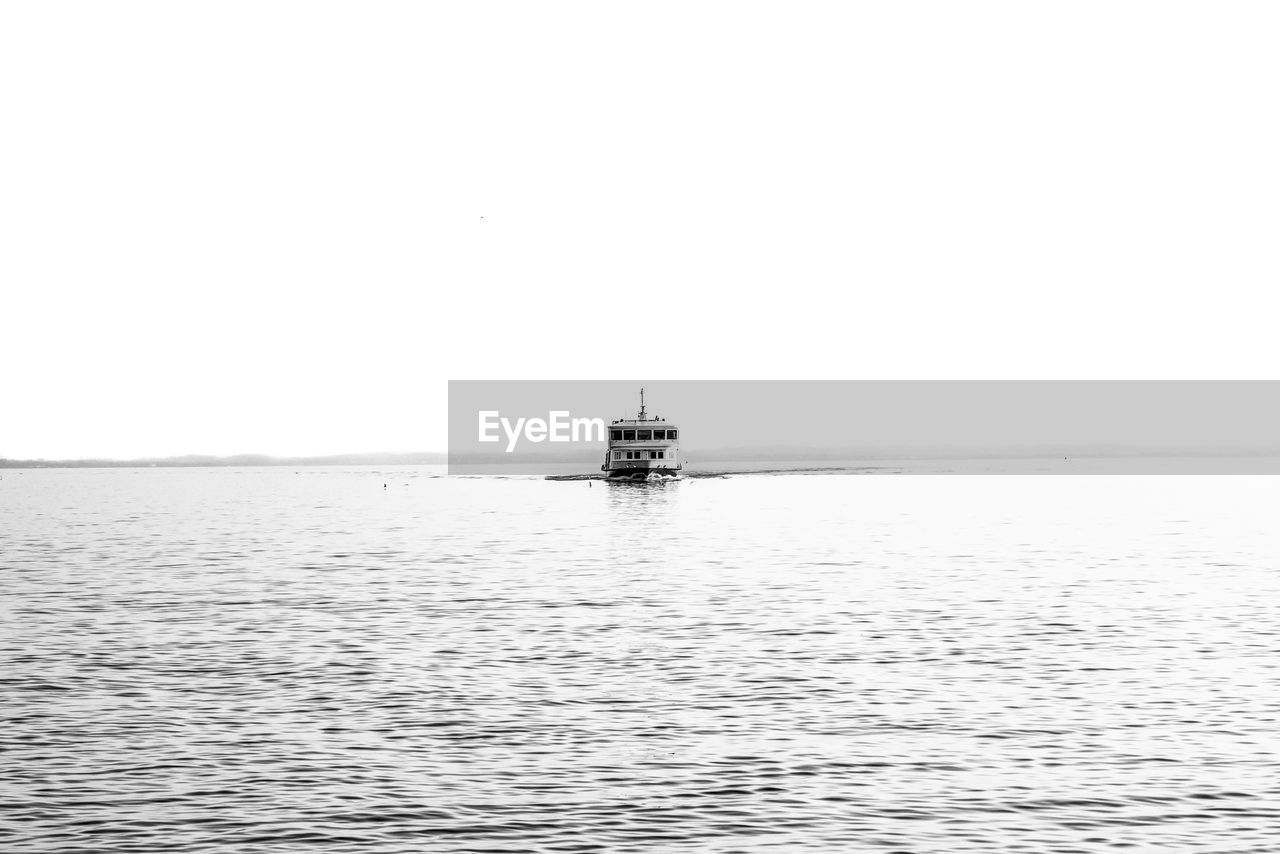 water, nautical vessel, sea, transportation, sky, mode of transportation, scenics - nature, nature, tranquility, horizon, beauty in nature, tranquil scene, copy space, day, sailing, ship, clear sky, horizon over water, waterfront, travel, vehicle, rippled, no people, outdoors, non-urban scene, black and white, boat, idyllic, silhouette, sailboat, distant
