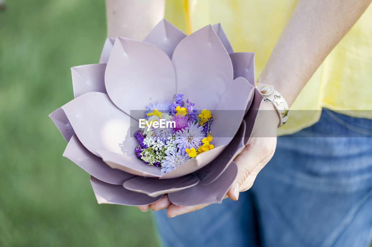 Midsection of woman with flowers