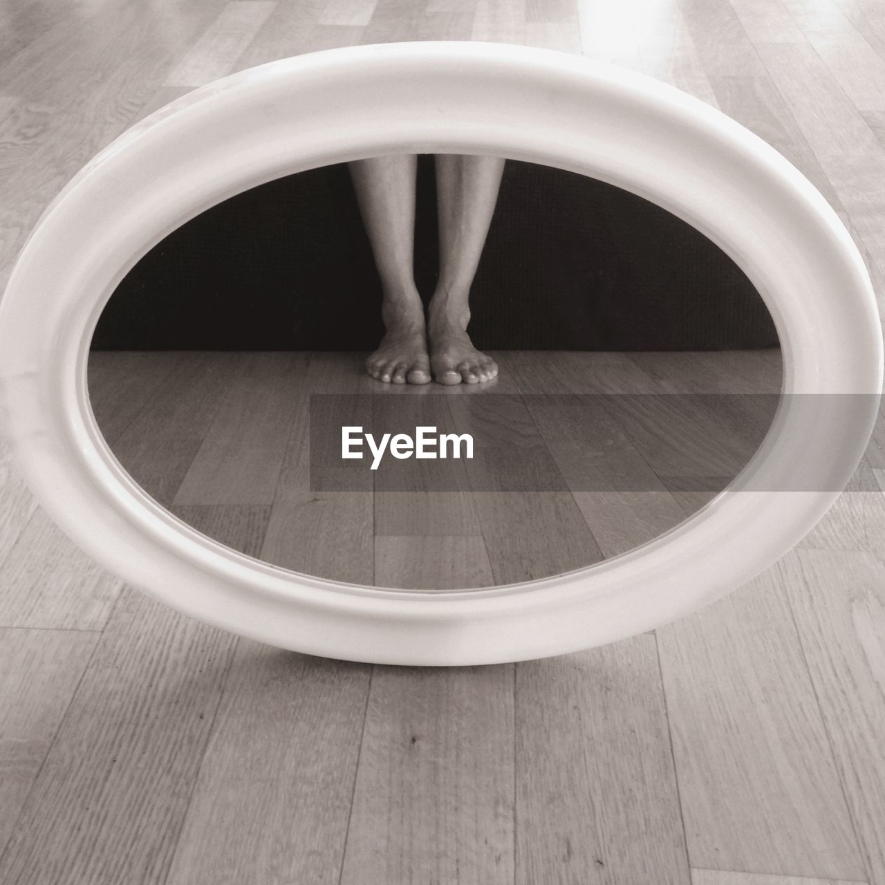 LOW SECTION OF WOMAN STANDING ON HARDWOOD FLOOR IN OFFICE