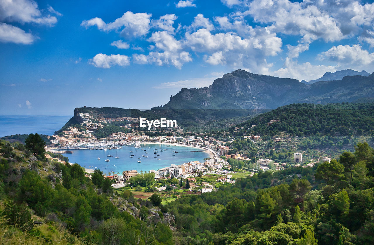 High angle view of sea by city amidst mountains