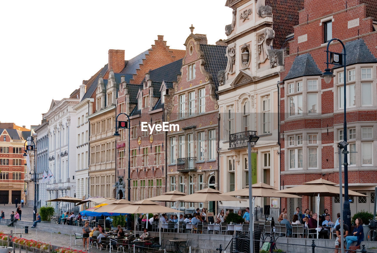 People on street against buildings in city