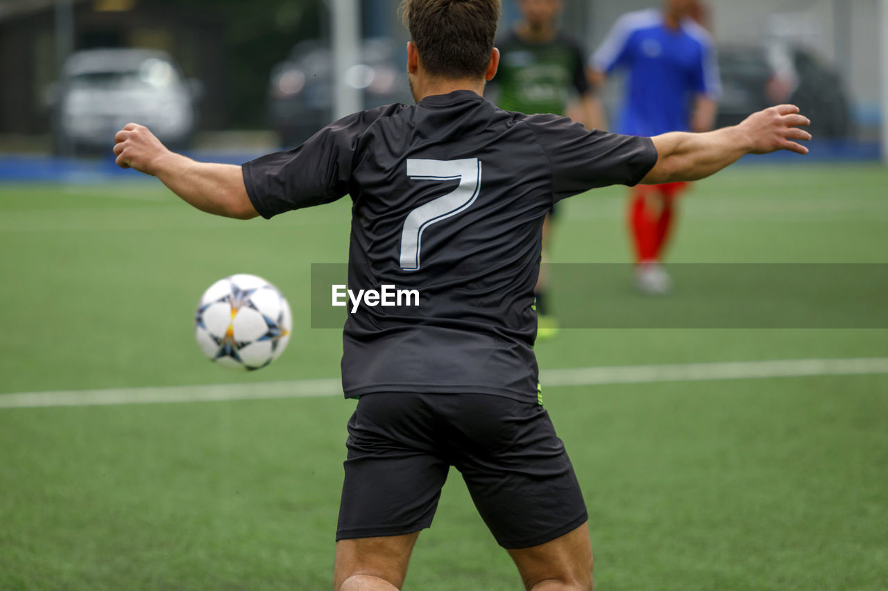 Rear view of soccer player playing field