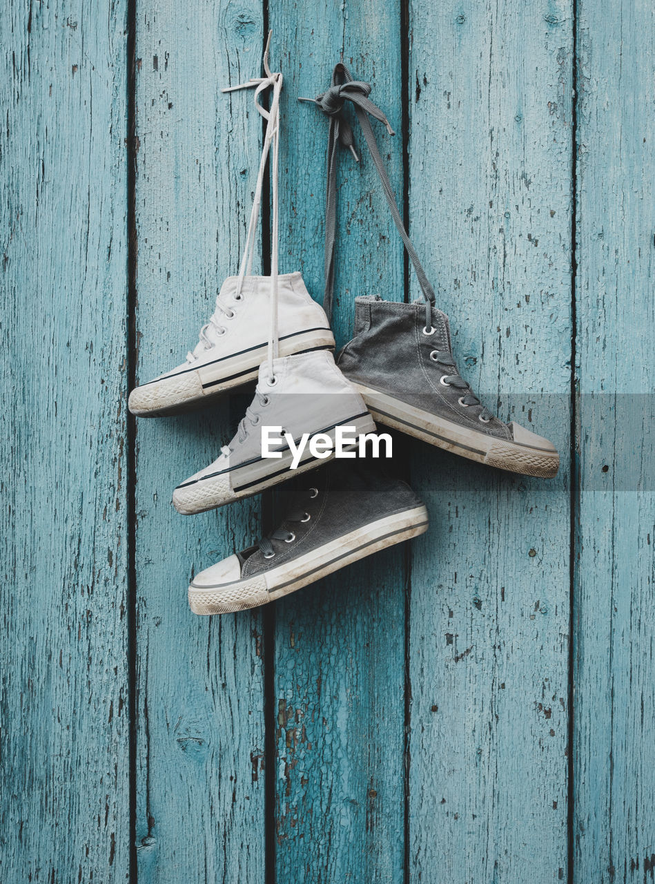 Close-up of shoes hanging on wooden wall