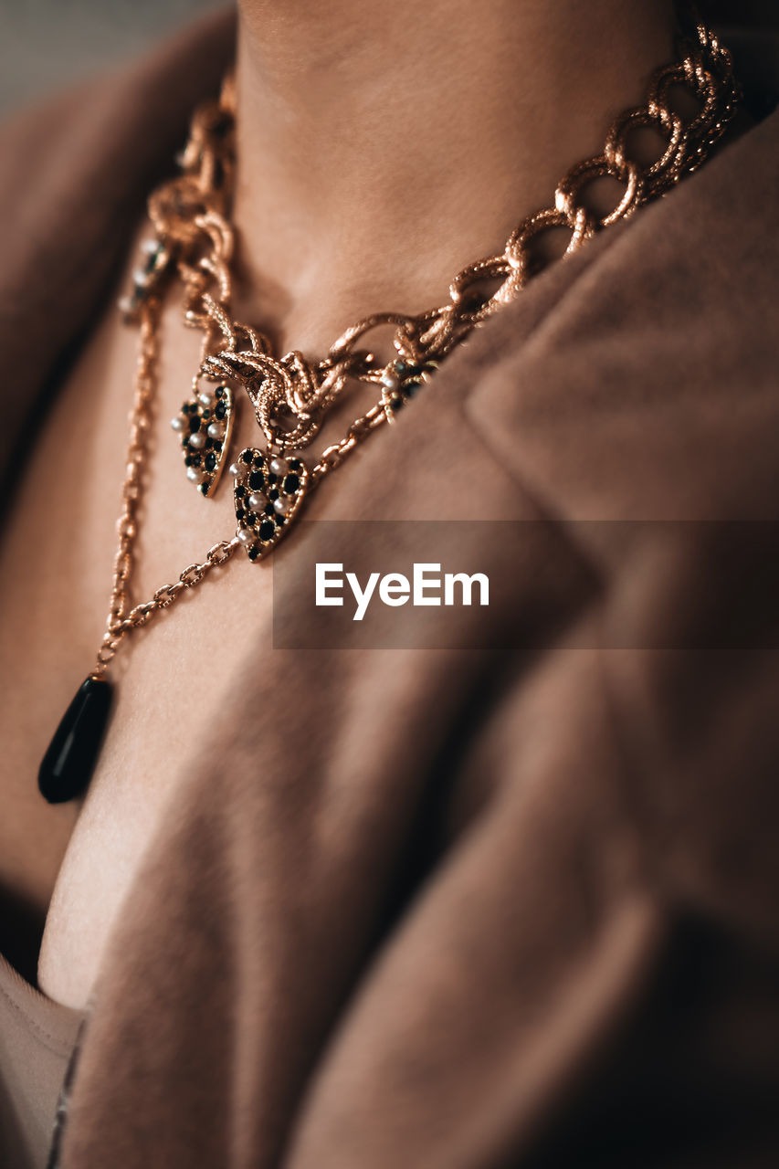 Golden chain hanging on a woman's neck. beautiful elegant luxury jewelry accessories