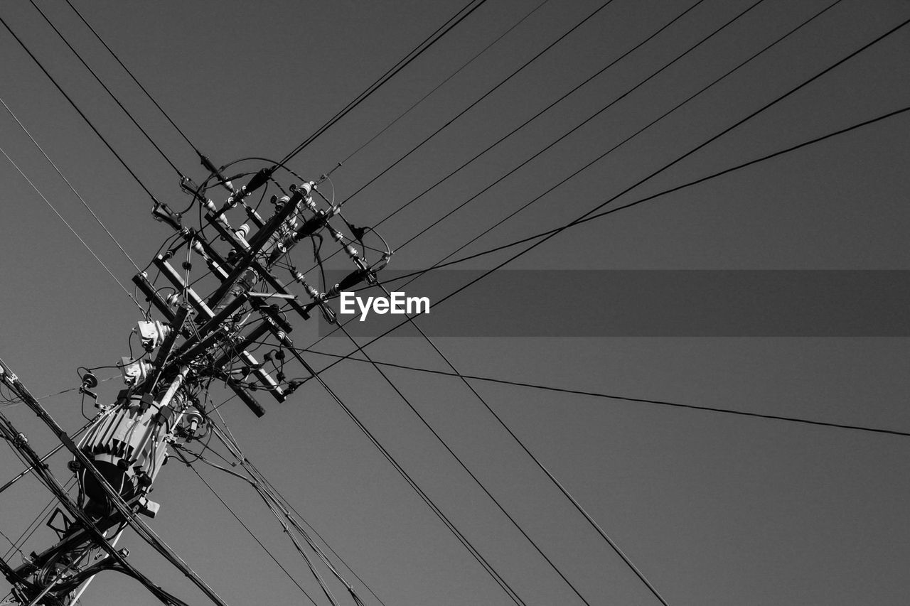 Low angle view of electricity pylon against clear sky