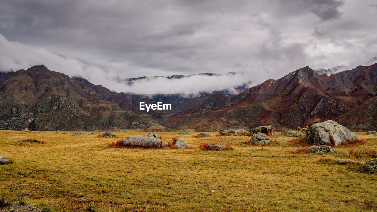 Scenic view of rocky mountains against cloudy sky