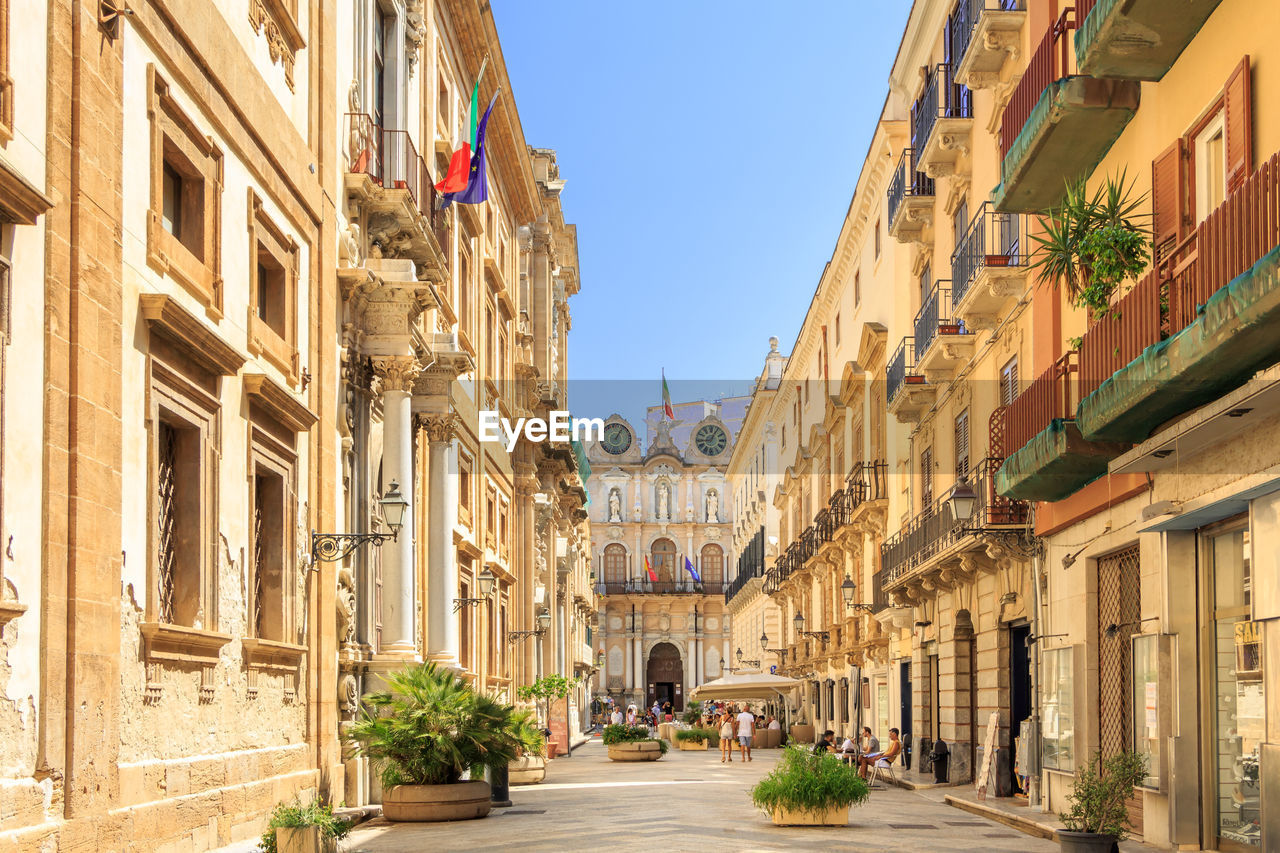 Street amidst buildings in town against sky