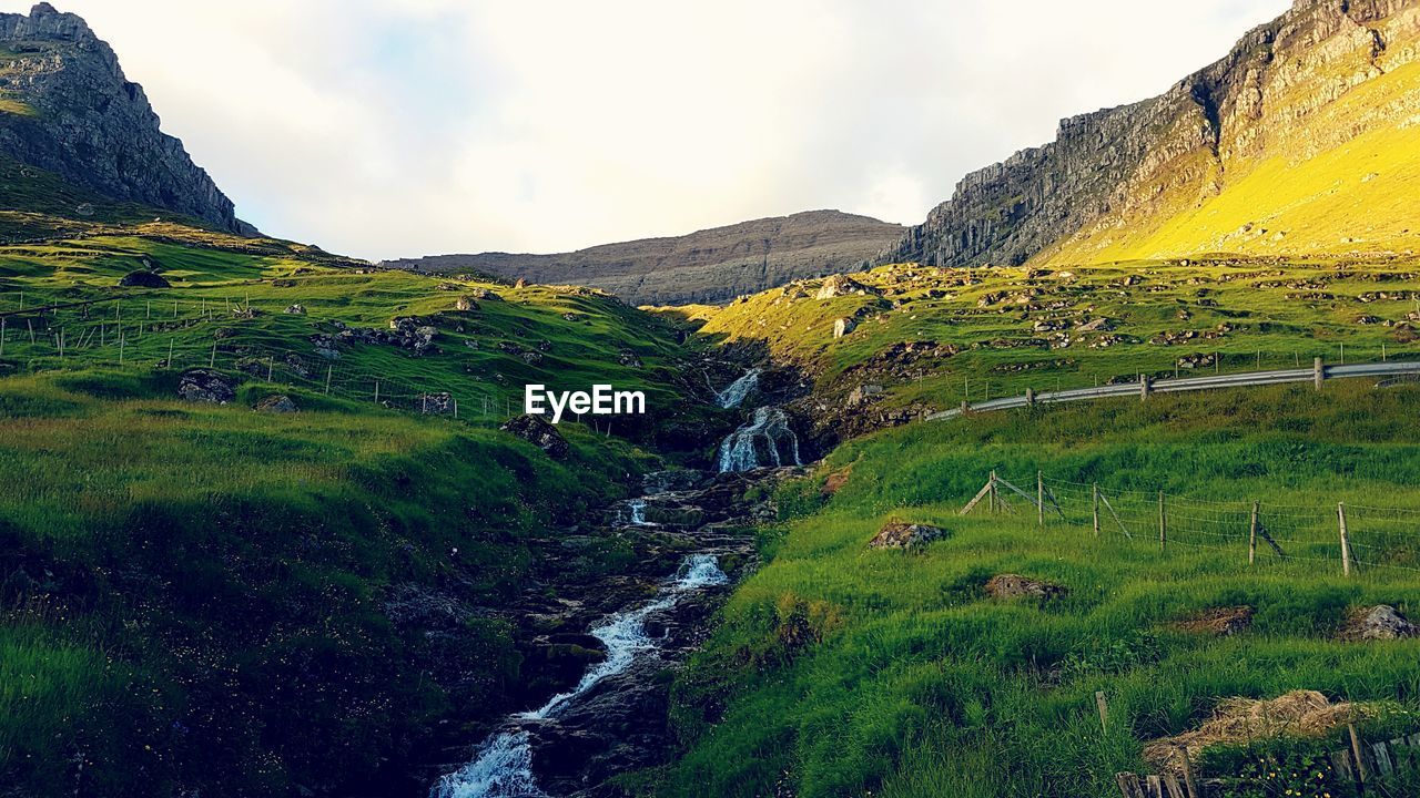 Scenic view of stream amidst mountains