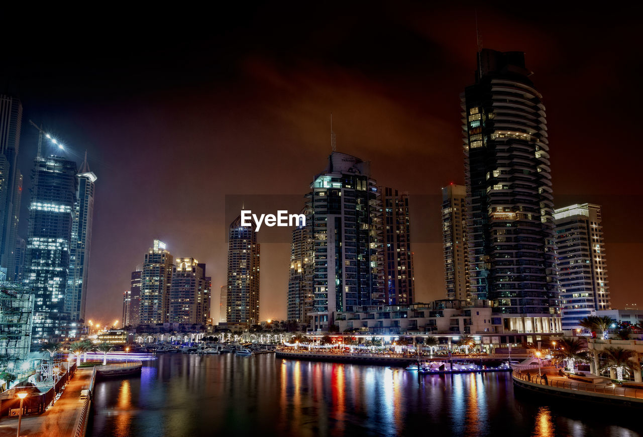 Illuminated dubai marina by canal at night