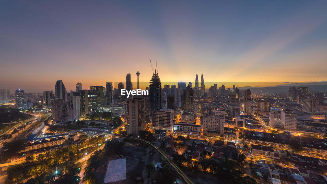 Aerial view of city lit up at sunset