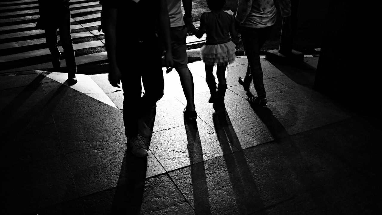 Low section of people walking on zebra crossing