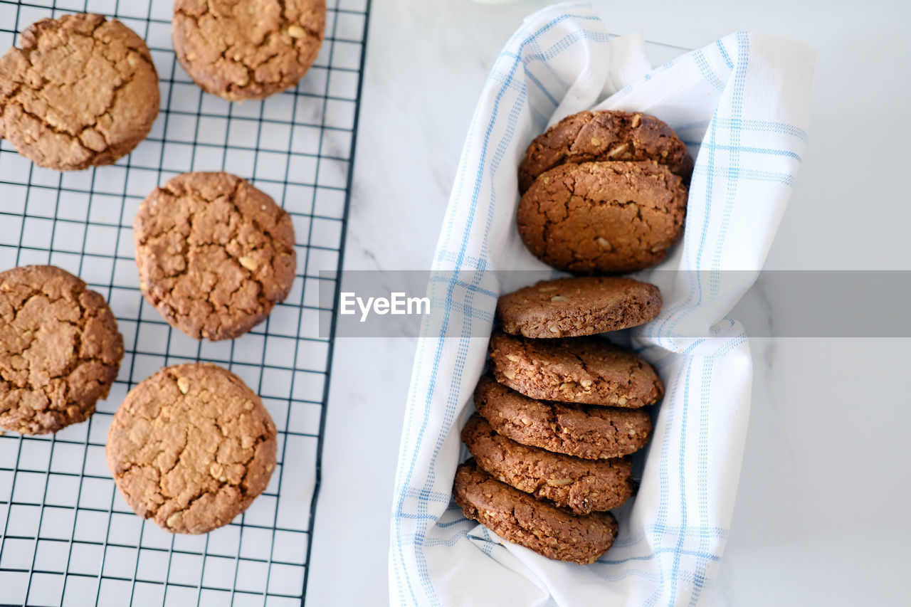 Freshly baked healthy vegan cookie on a cooling rack stand on a table next to milk. view from