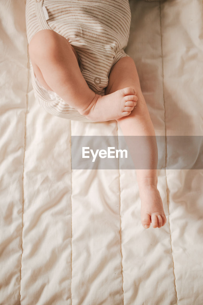 Soft focus close-up of newborn baby feet on a white blanket.