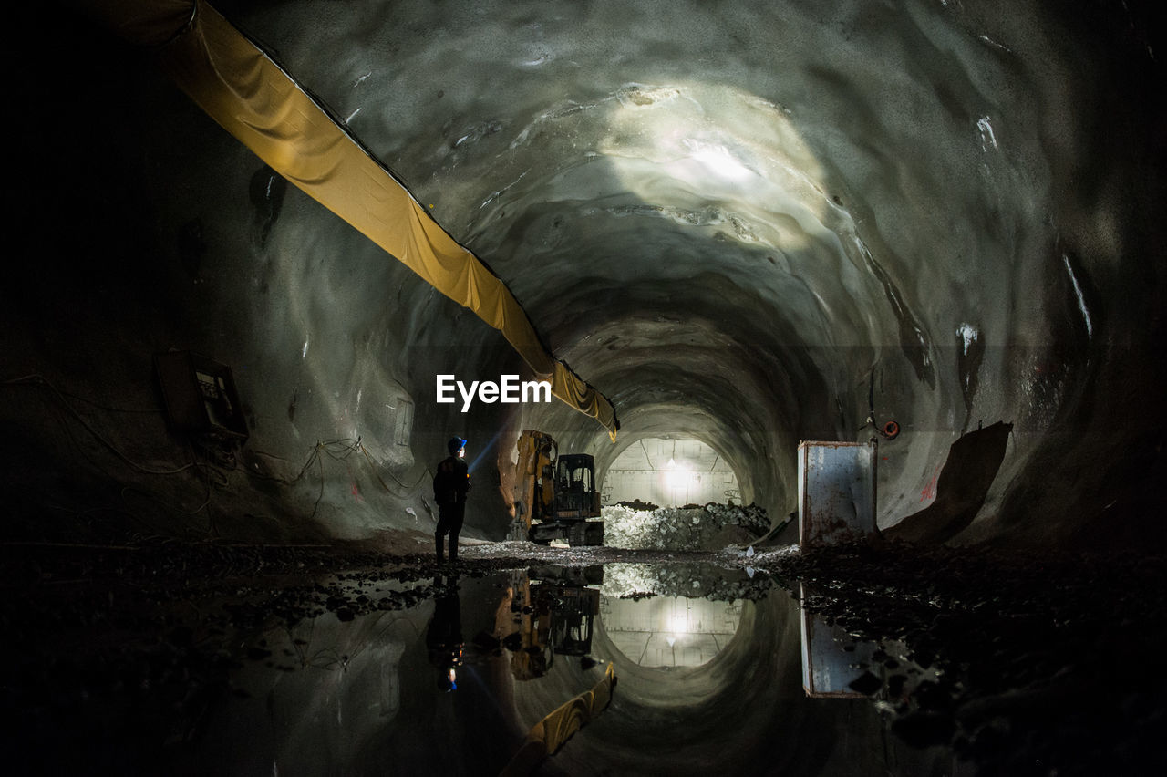 Rear view of man standing in tunnel