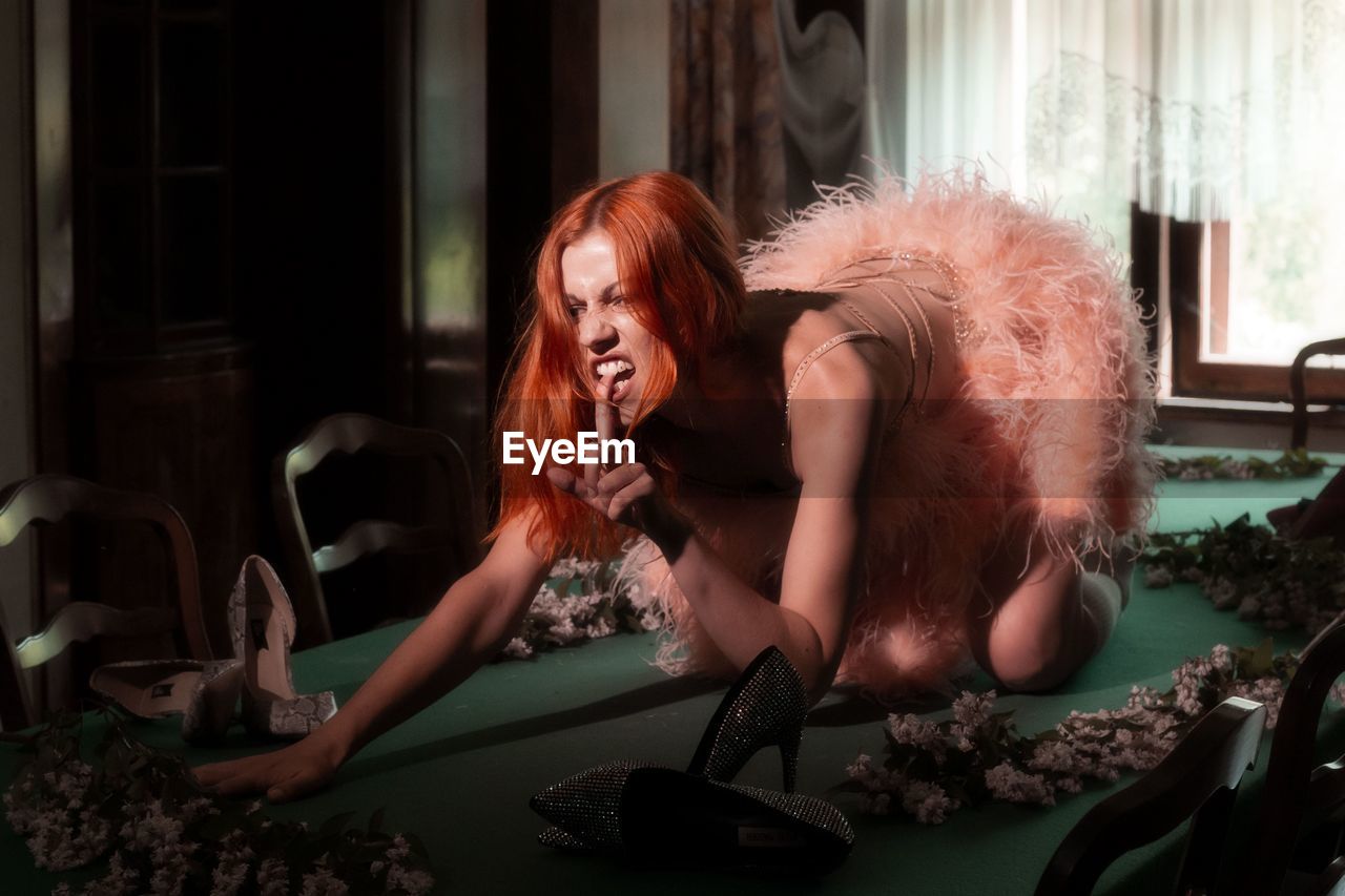 Femme fatale in pink dress on the pool table