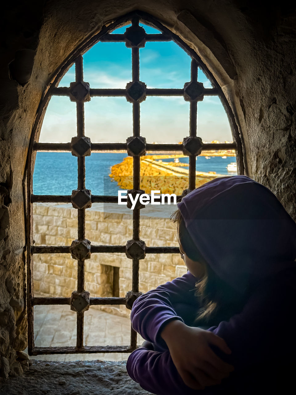 window, architecture, blue, one person, light, built structure, nature, indoors, water, adult, looking, day, darkness, men, sitting, building, sky, arch, religion, sunlight, reflection
