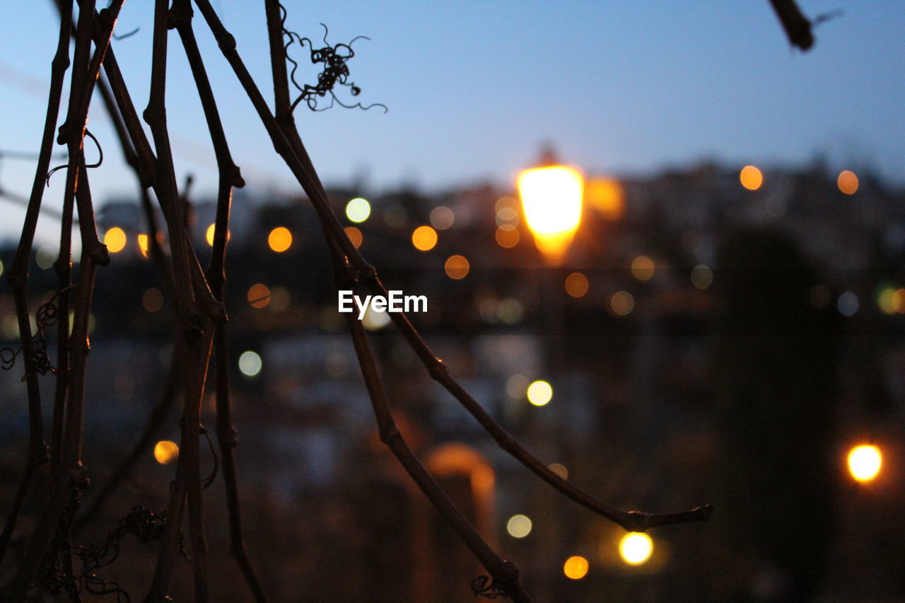 VIEW OF ILLUMINATED CITY AT SUNSET