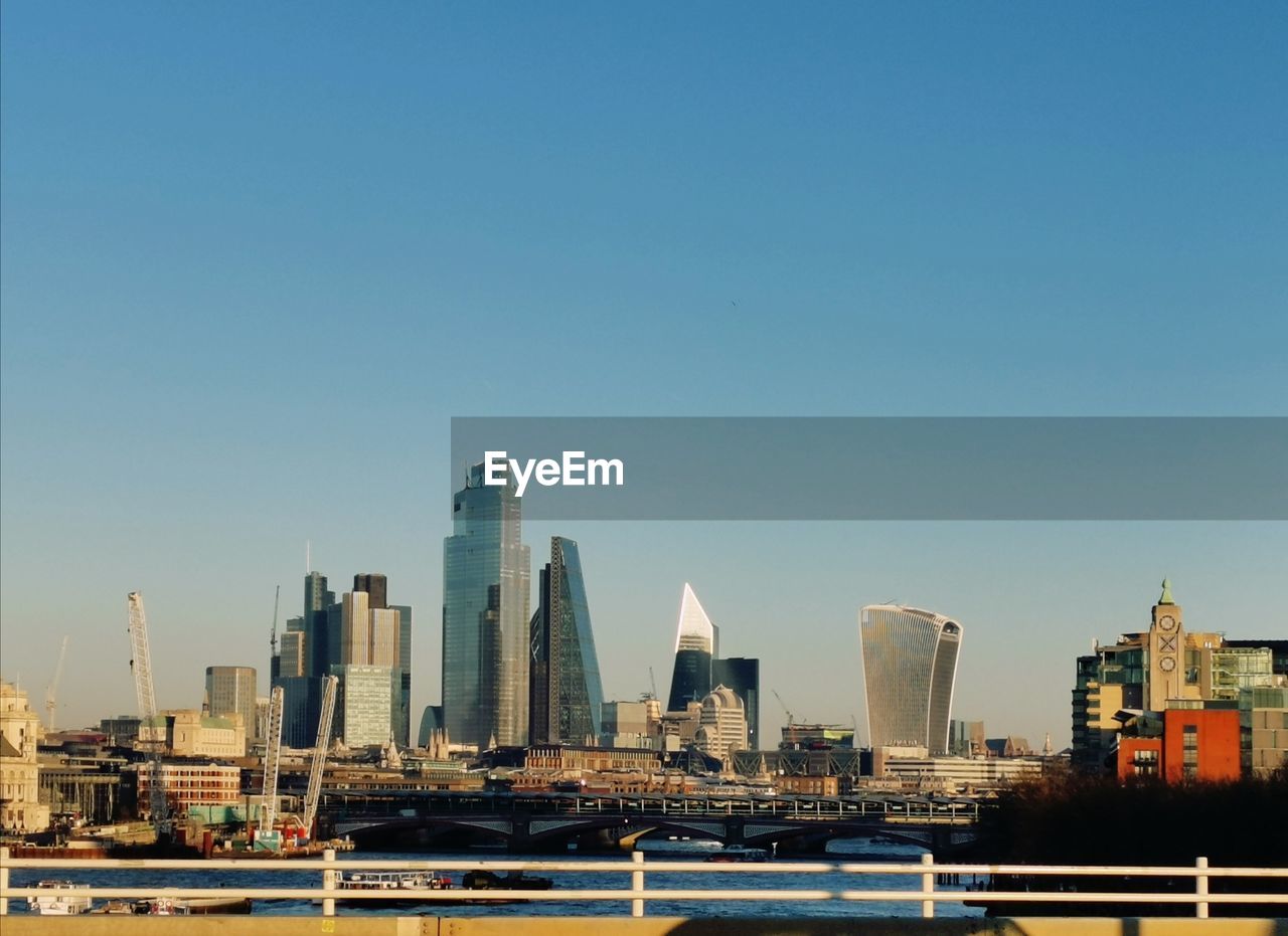 Modern buildings in city against clear sky