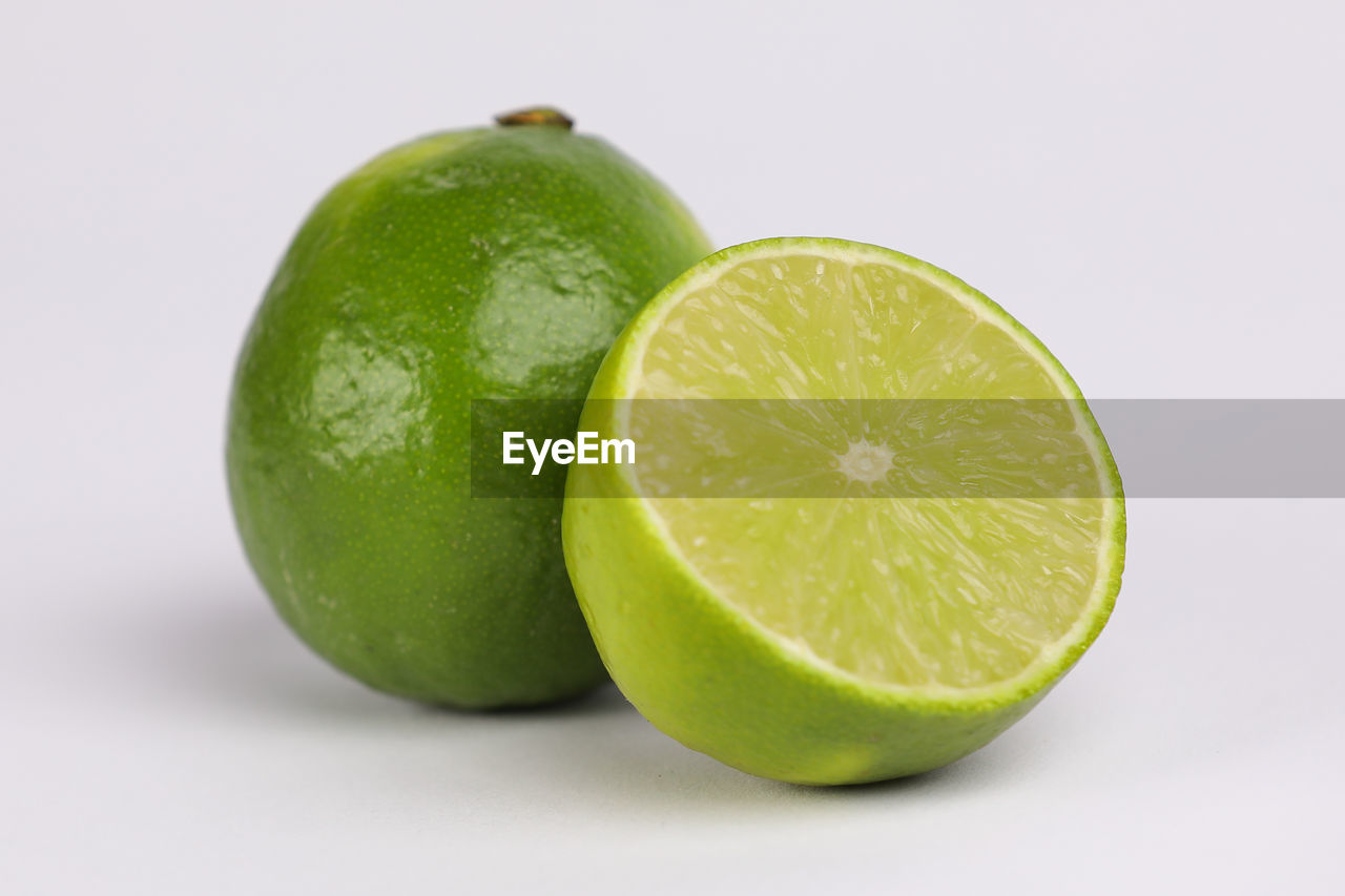 CLOSE-UP OF GREEN LEMON SLICE AGAINST WHITE BACKGROUND