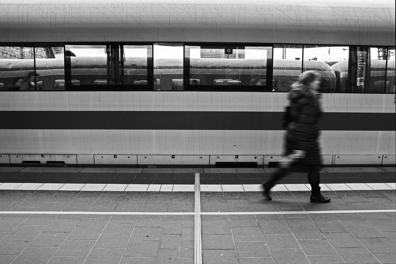 BLURRED MOTION OF WOMAN ON RAILROAD STATION PLATFORM