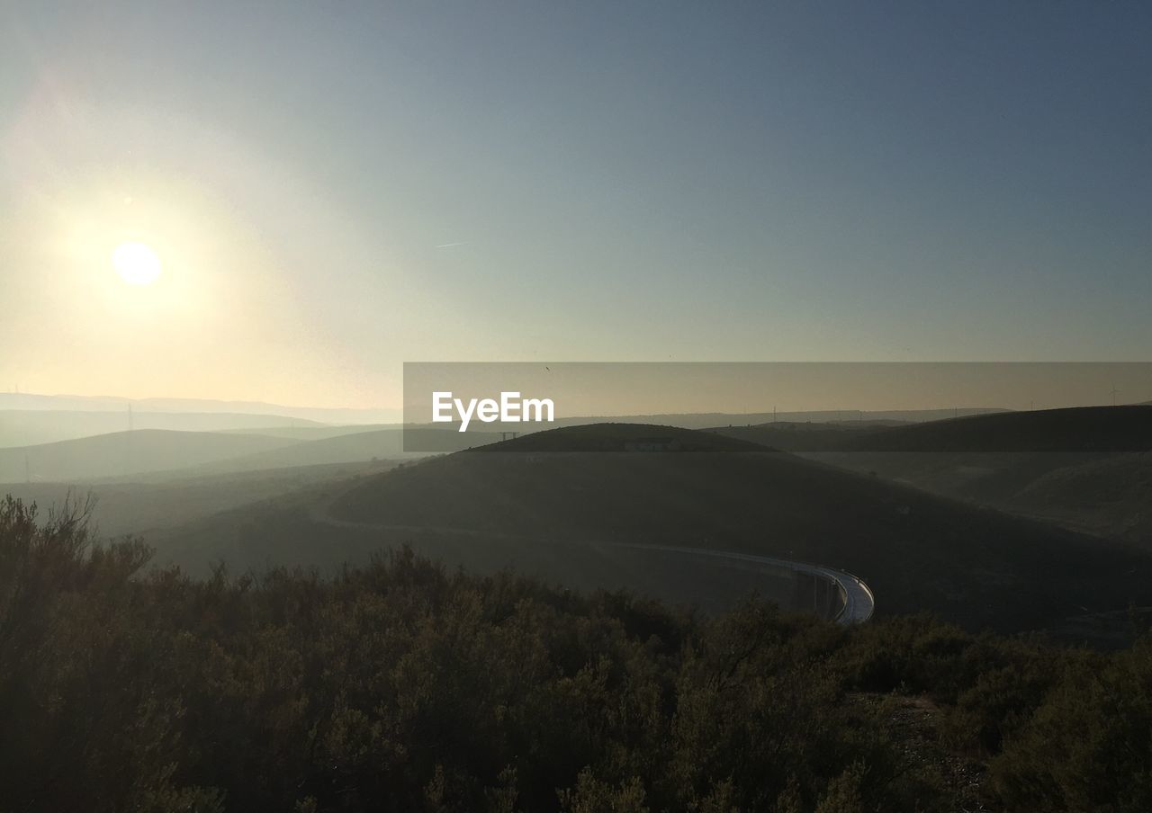 Scenic view of mountains against clear sky at sunset