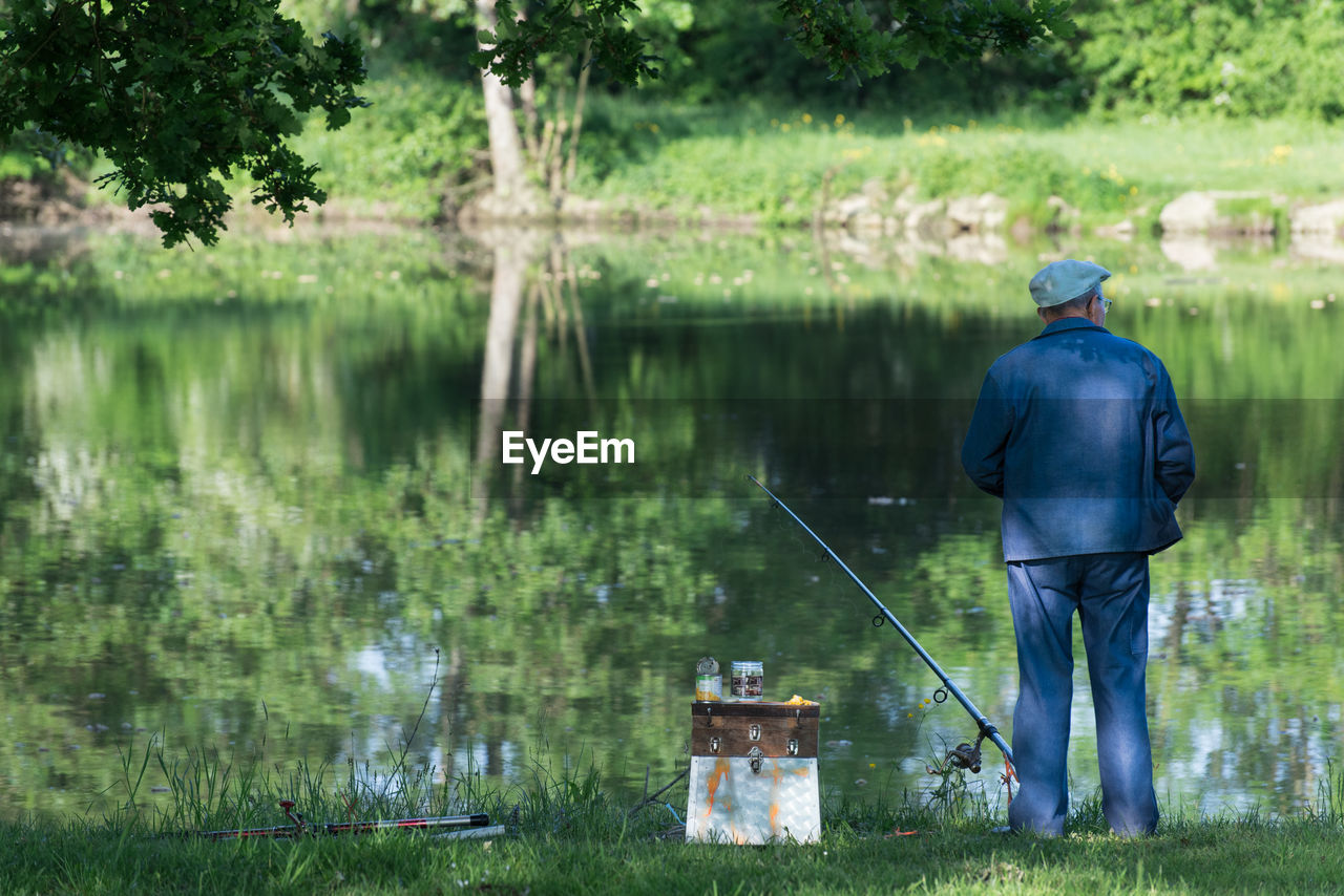 Rear view of man fishing in lake