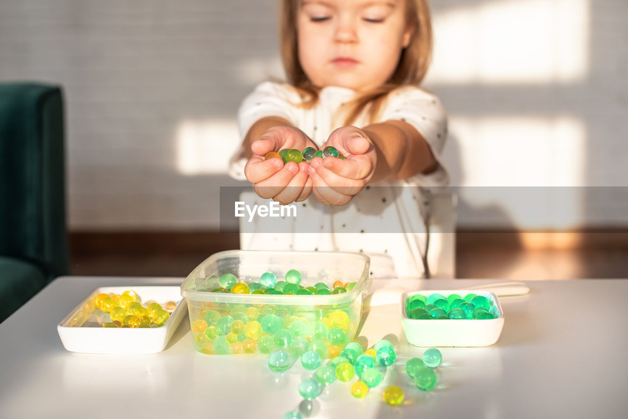 Cute girl playing with marbles