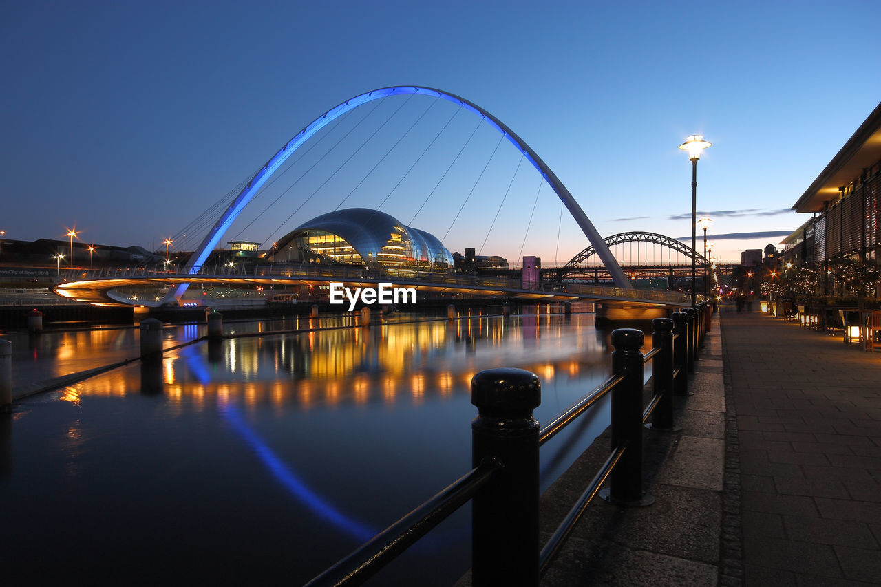 VIEW OF ILLUMINATED BRIDGE OVER RIVER