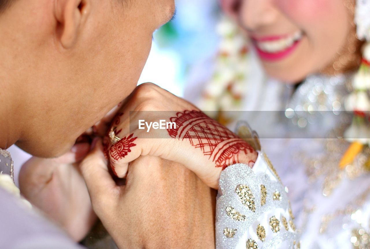 Groom kissing hands of bride