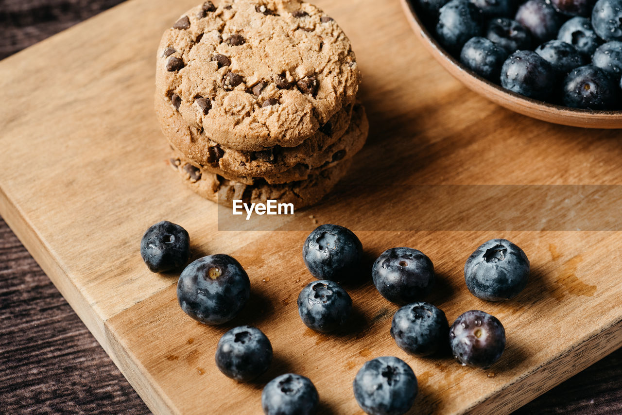 Blueberry and cookies on wooden board