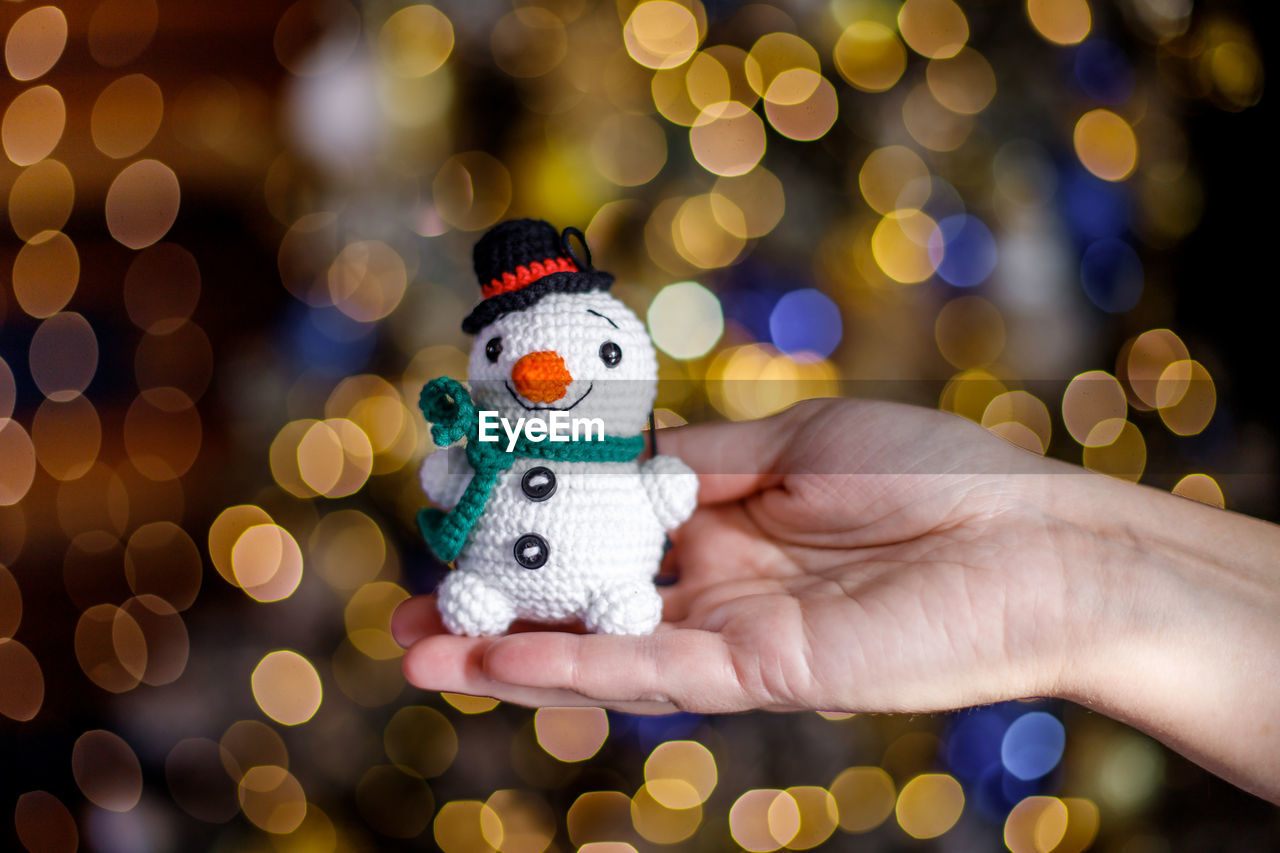 Cropped hand of woman holding snowman