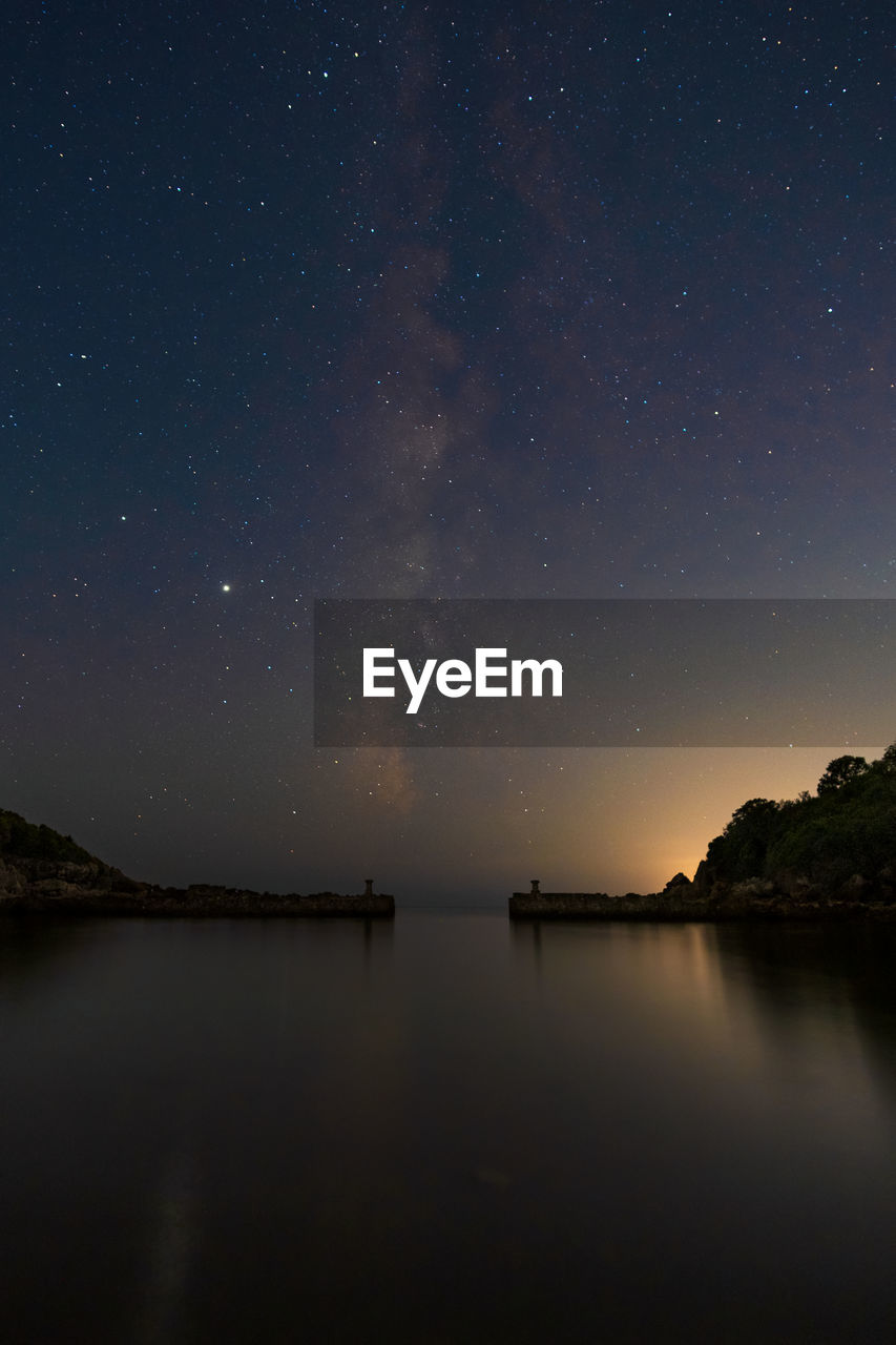 Scenic view of lake against sky at night