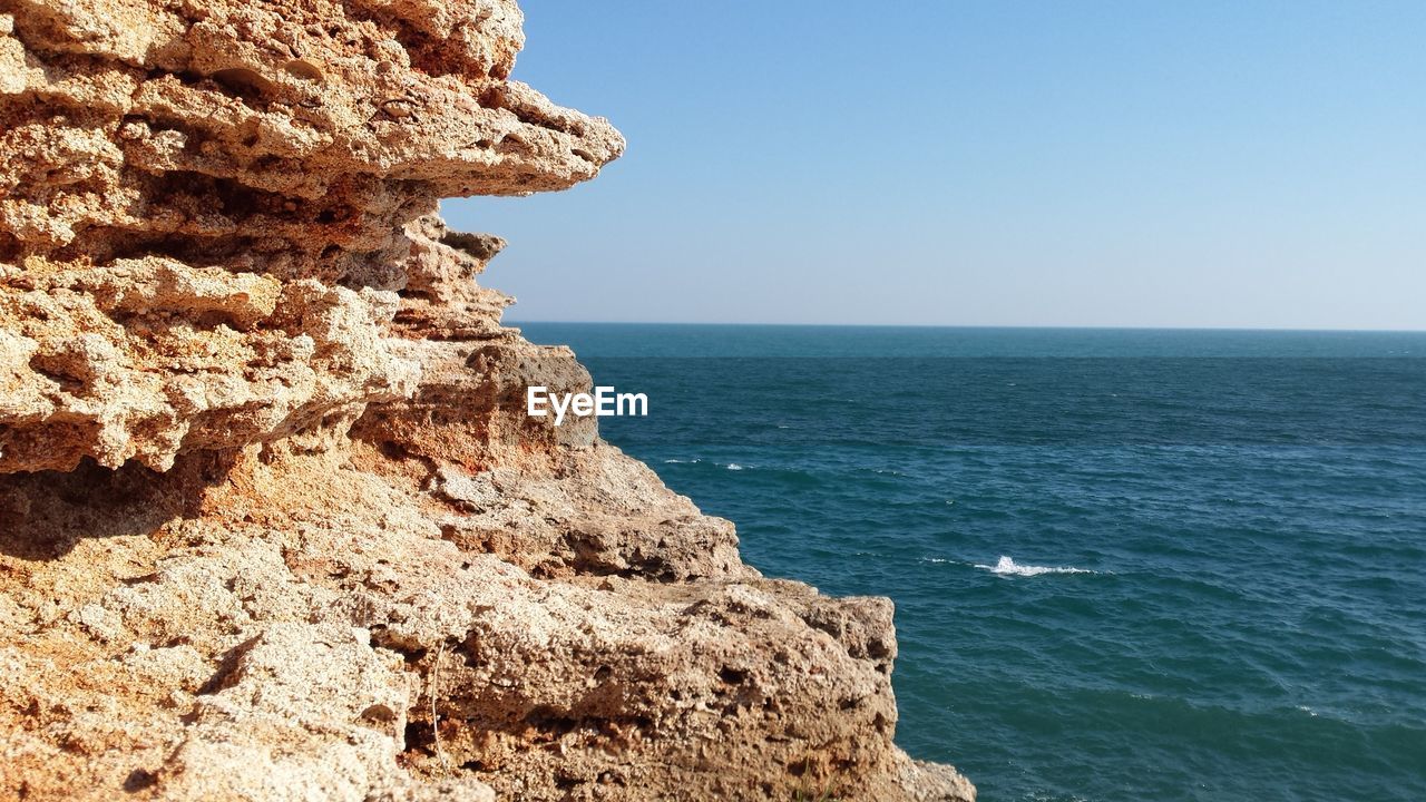 Scenic shot of rock formations by the blue sea