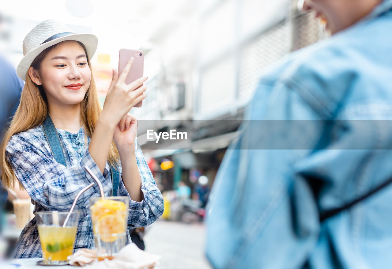 PORTRAIT OF SMILING MAN HOLDING SMART PHONE