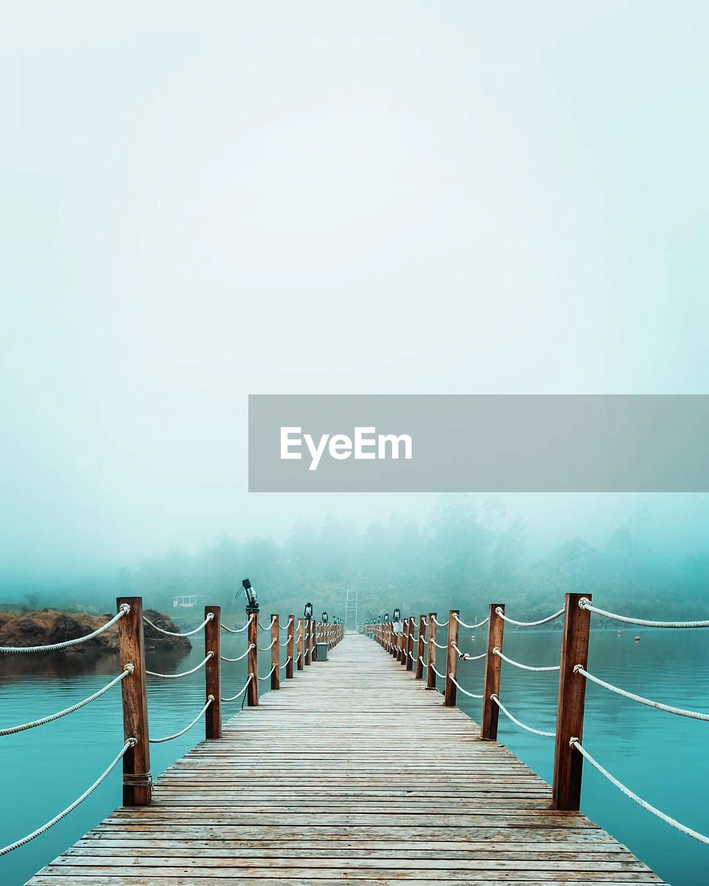 Wooden pier in sea against sky