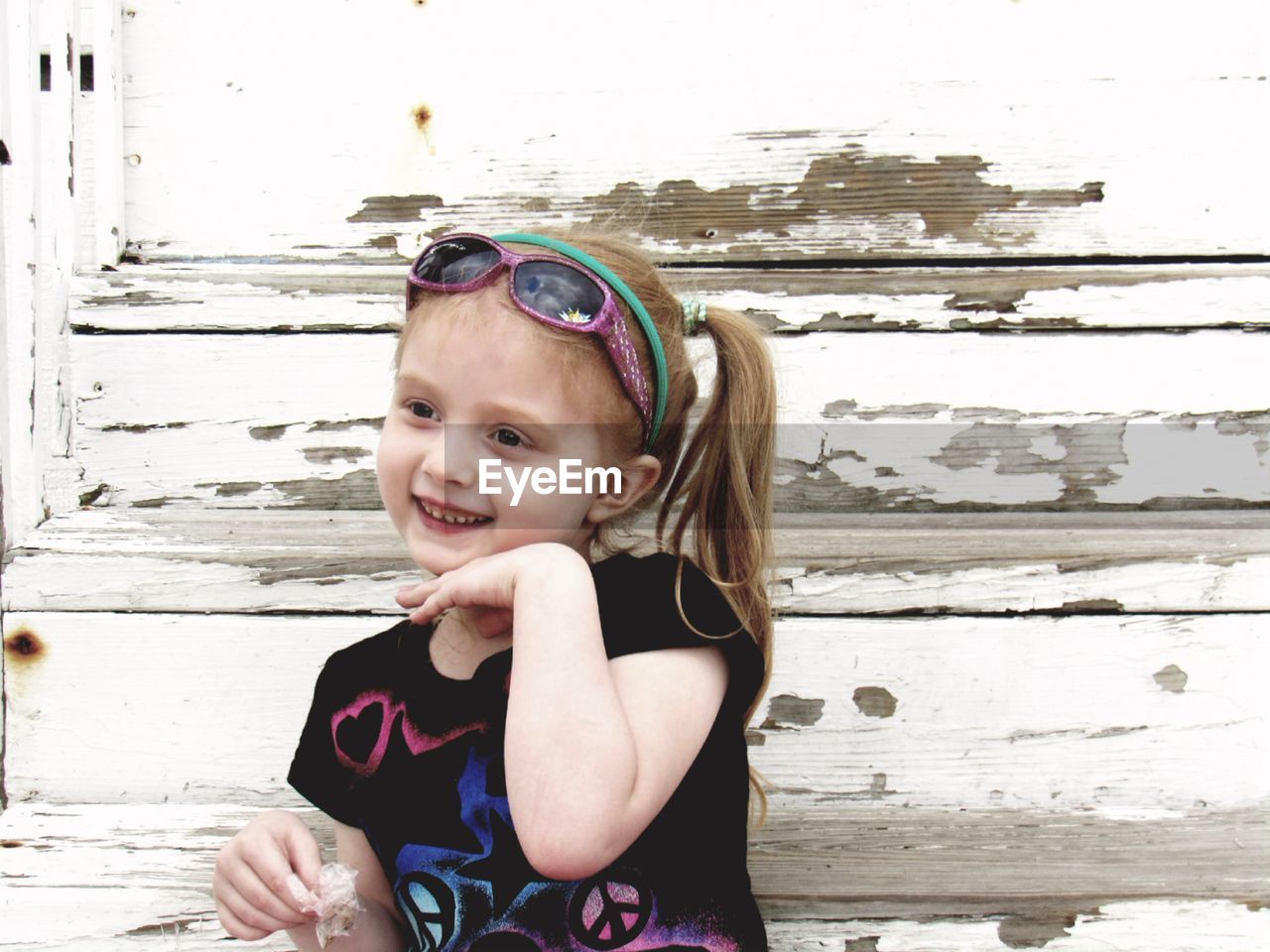 Cute girl smiling against wooden wall