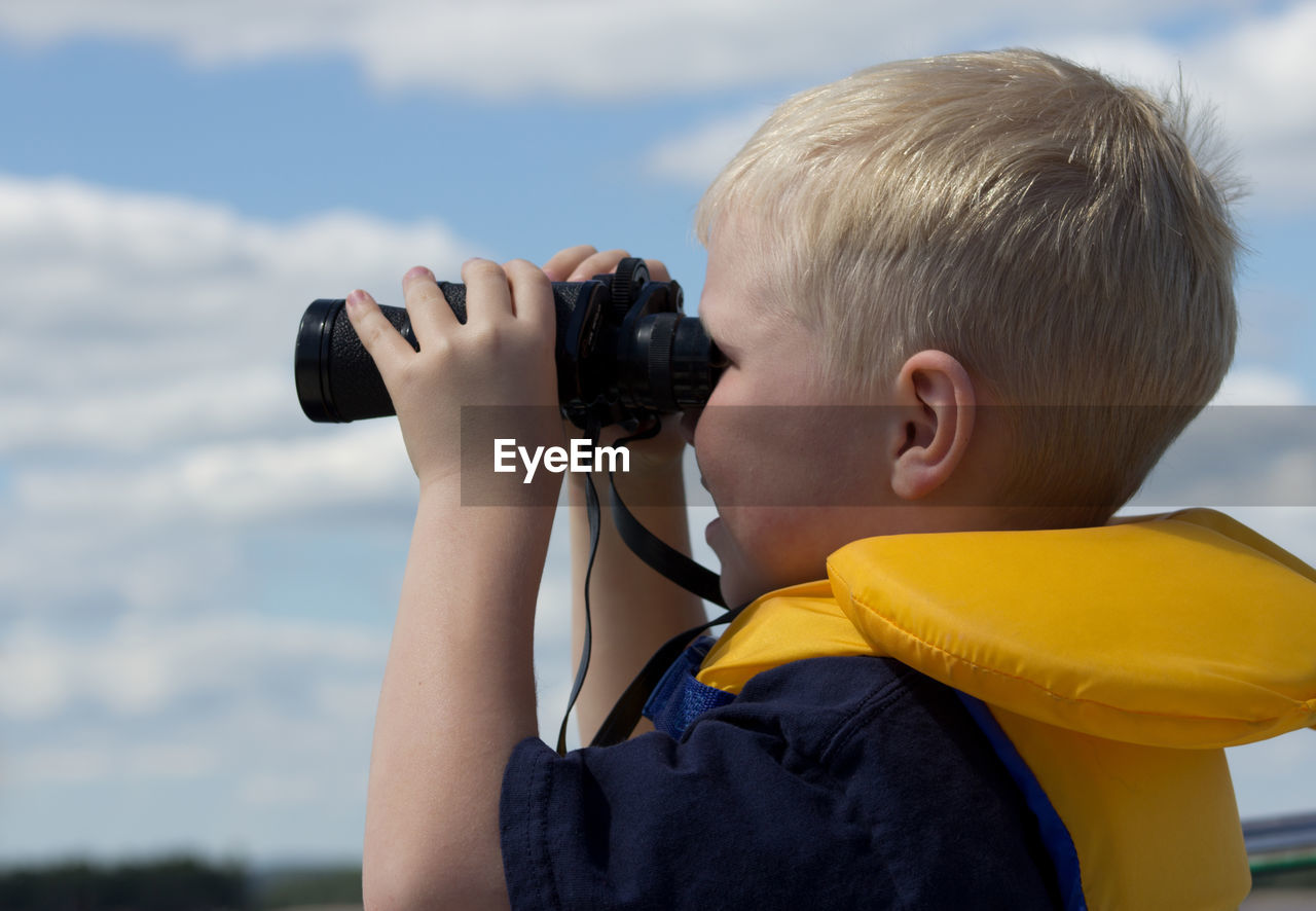 Rear view of boy photographing