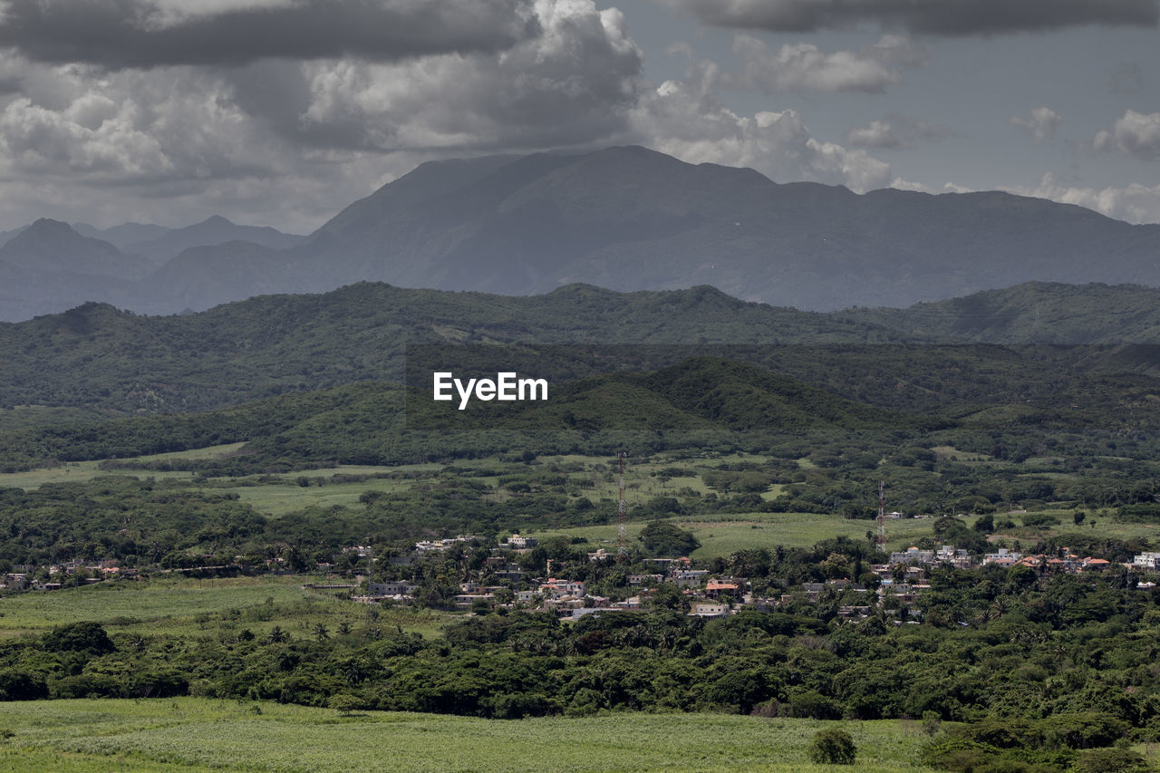 SCENIC VIEW OF TREES AND MOUNTAINS AGAINST SKY