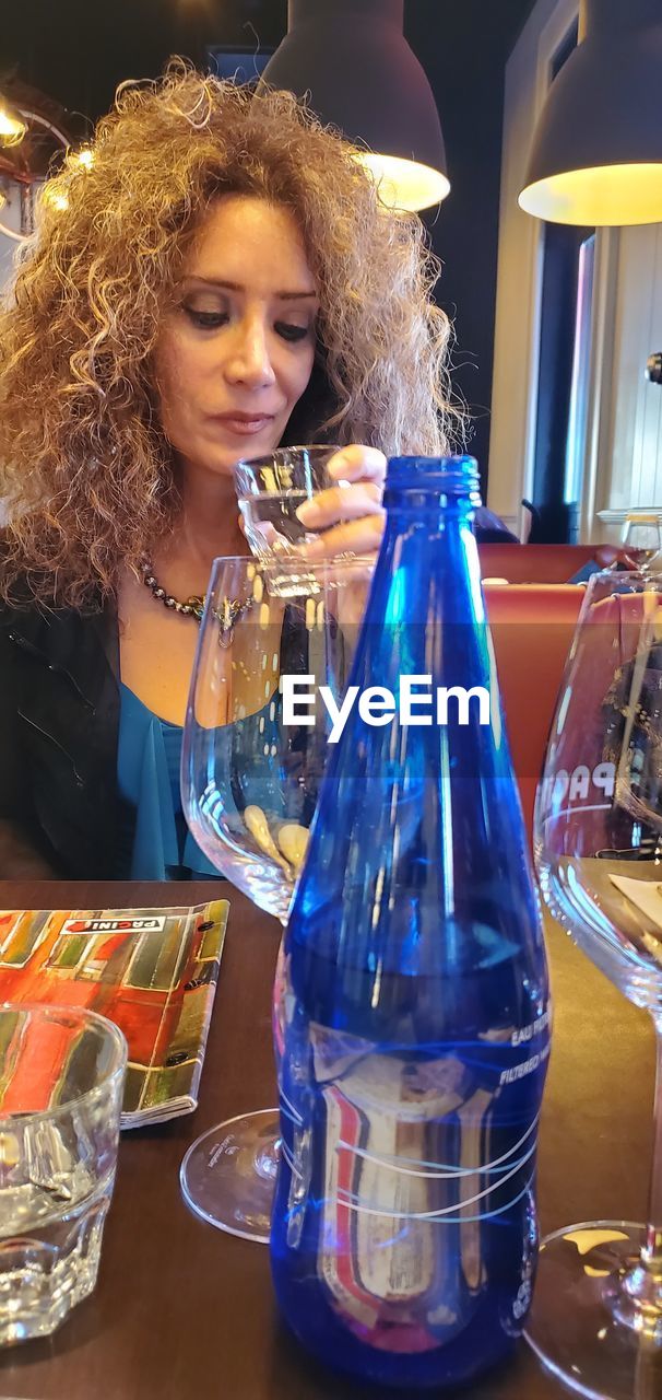 YOUNG WOMAN DRINKING GLASS BOTTLE