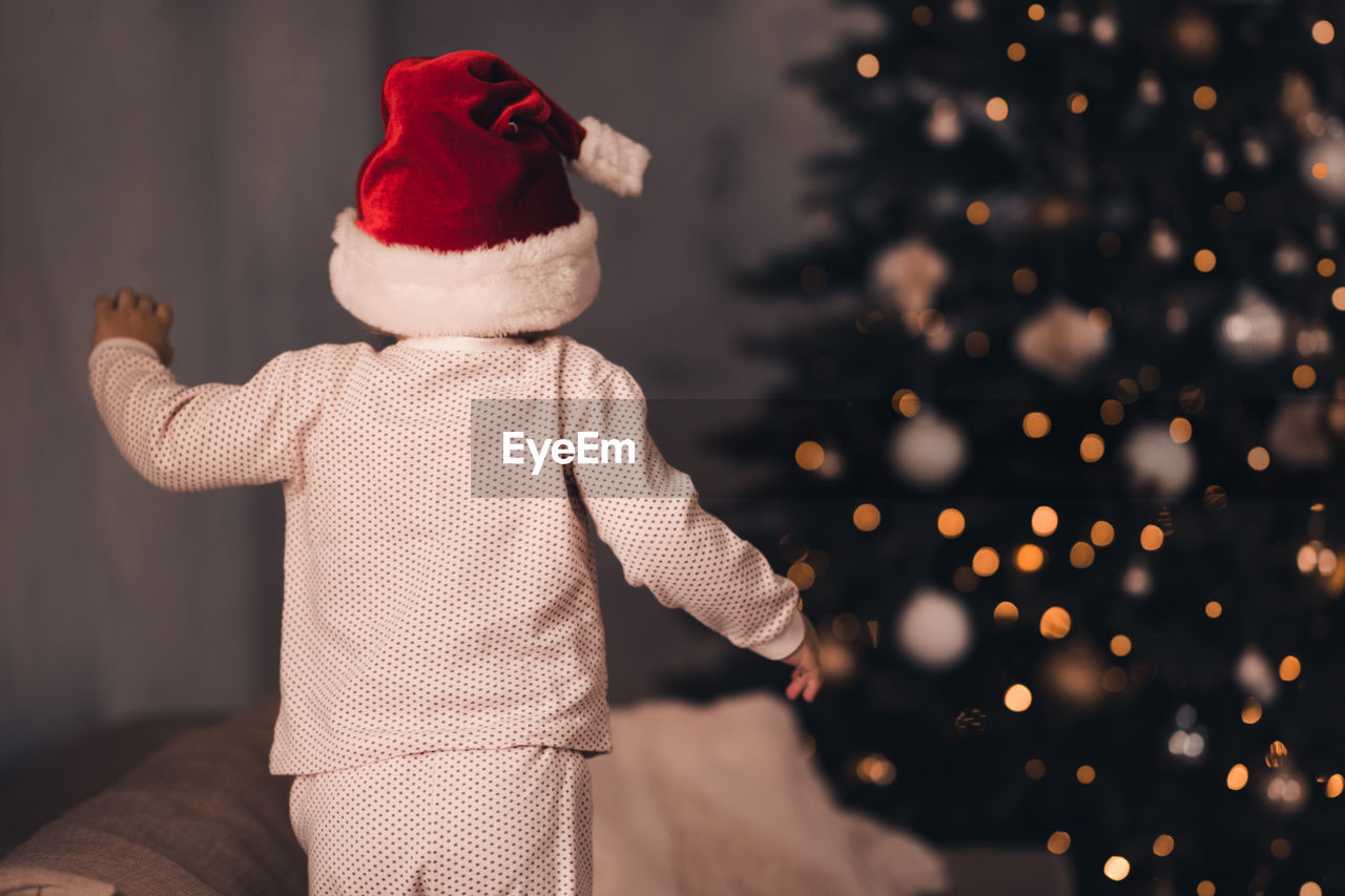 Rear view of girl looking at christmas tree