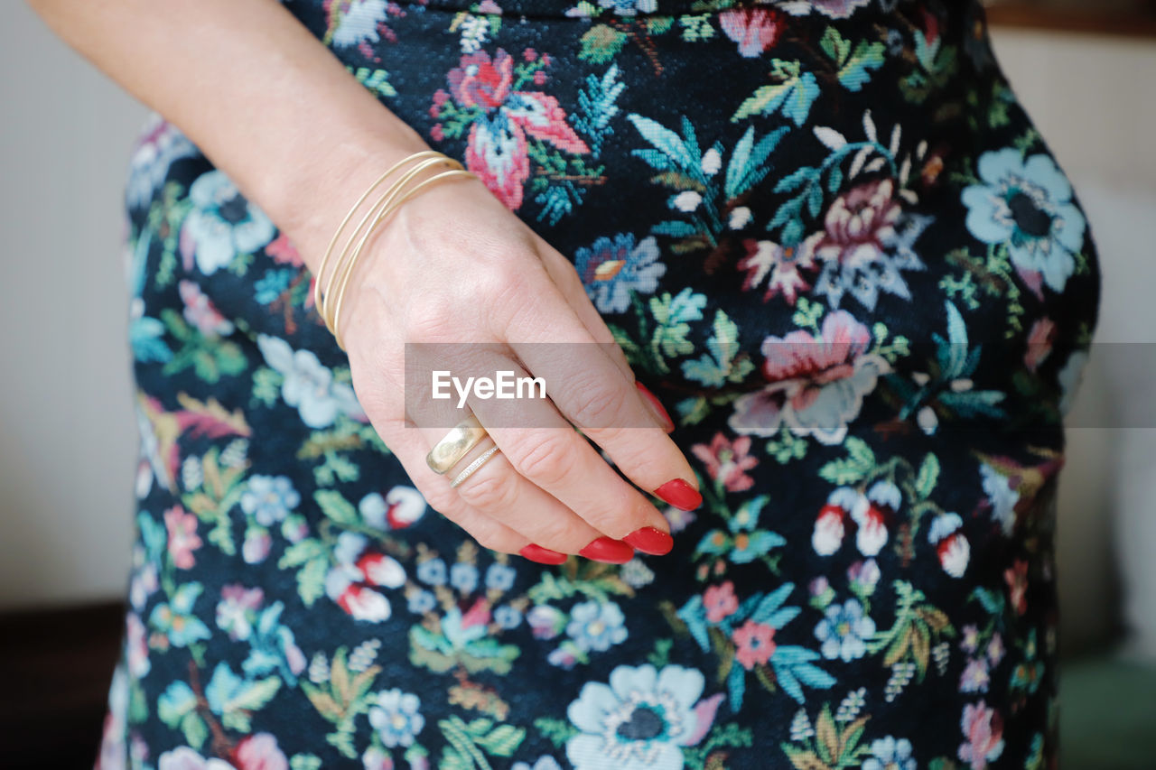 Close-up midsection of woman wearing floral patterned dress