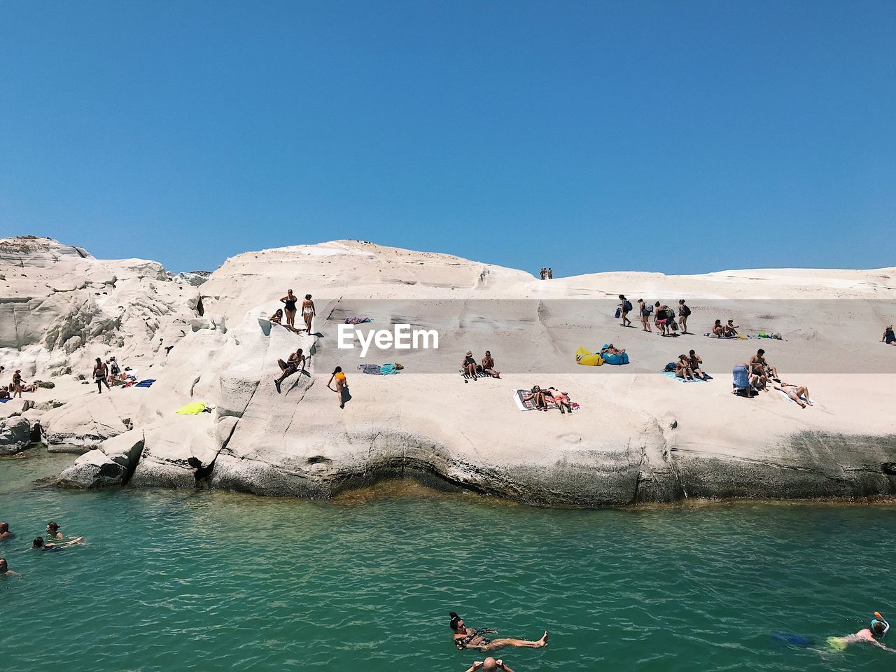 PEOPLE ON SHORE AGAINST SKY
