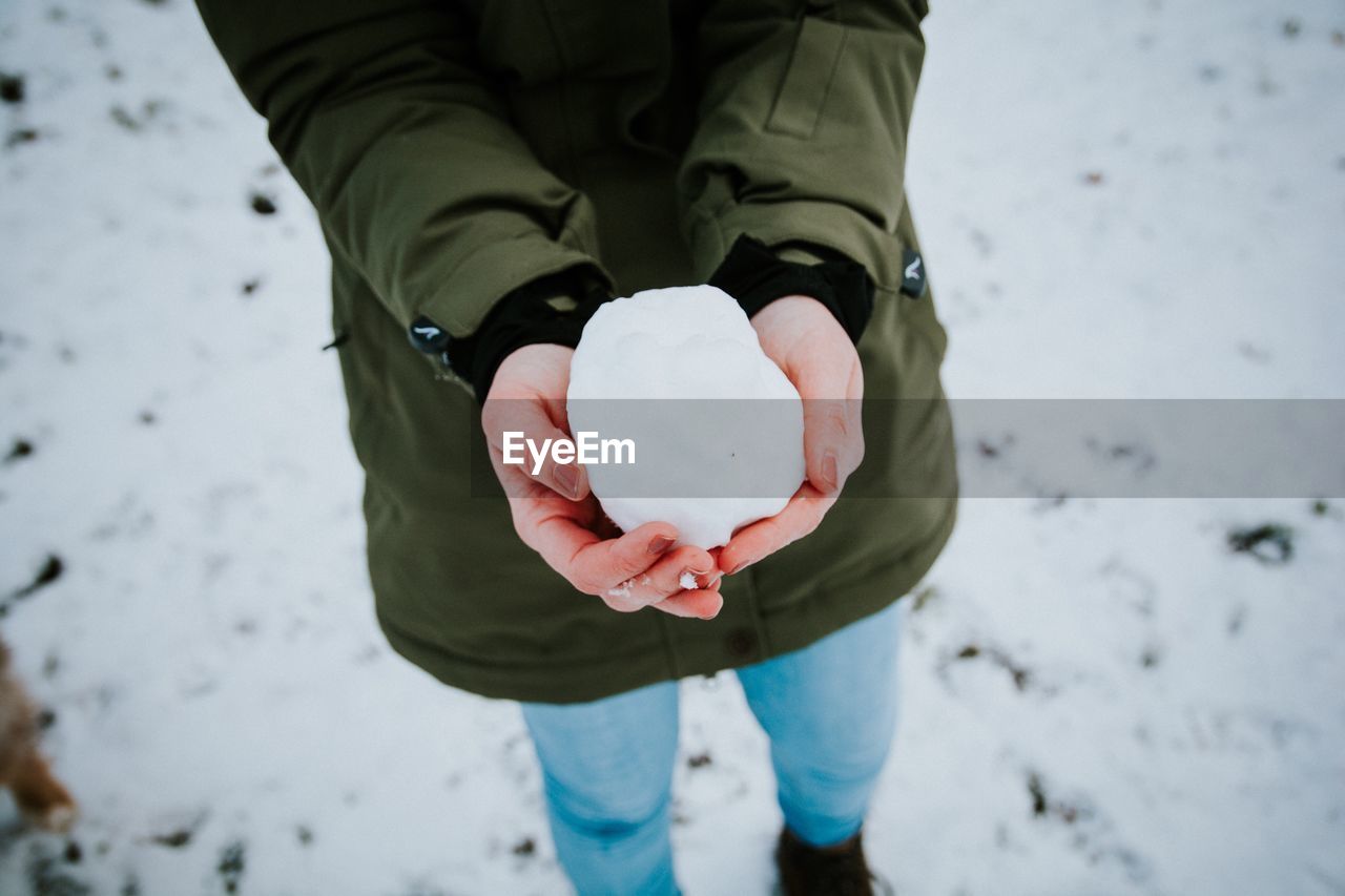 Close-up of hands holding a snowball