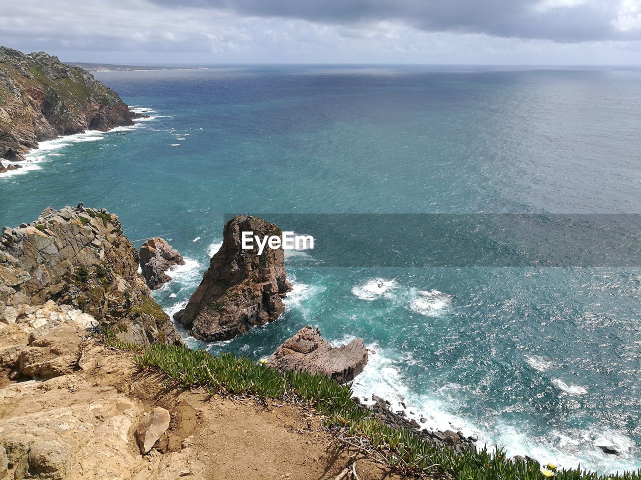 High angle view of rock formation by sea against sky