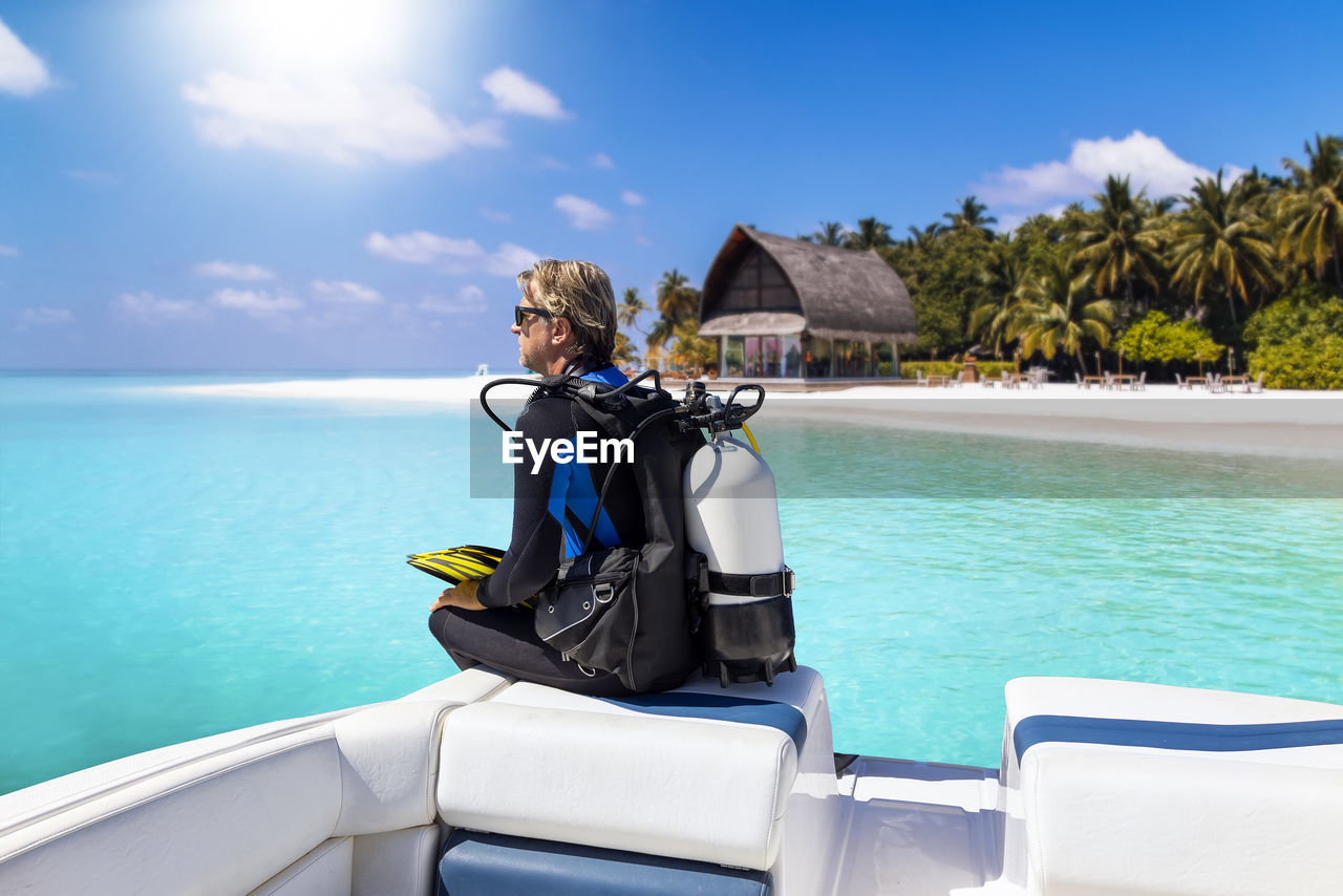 rear view of woman in boat in sea against sky