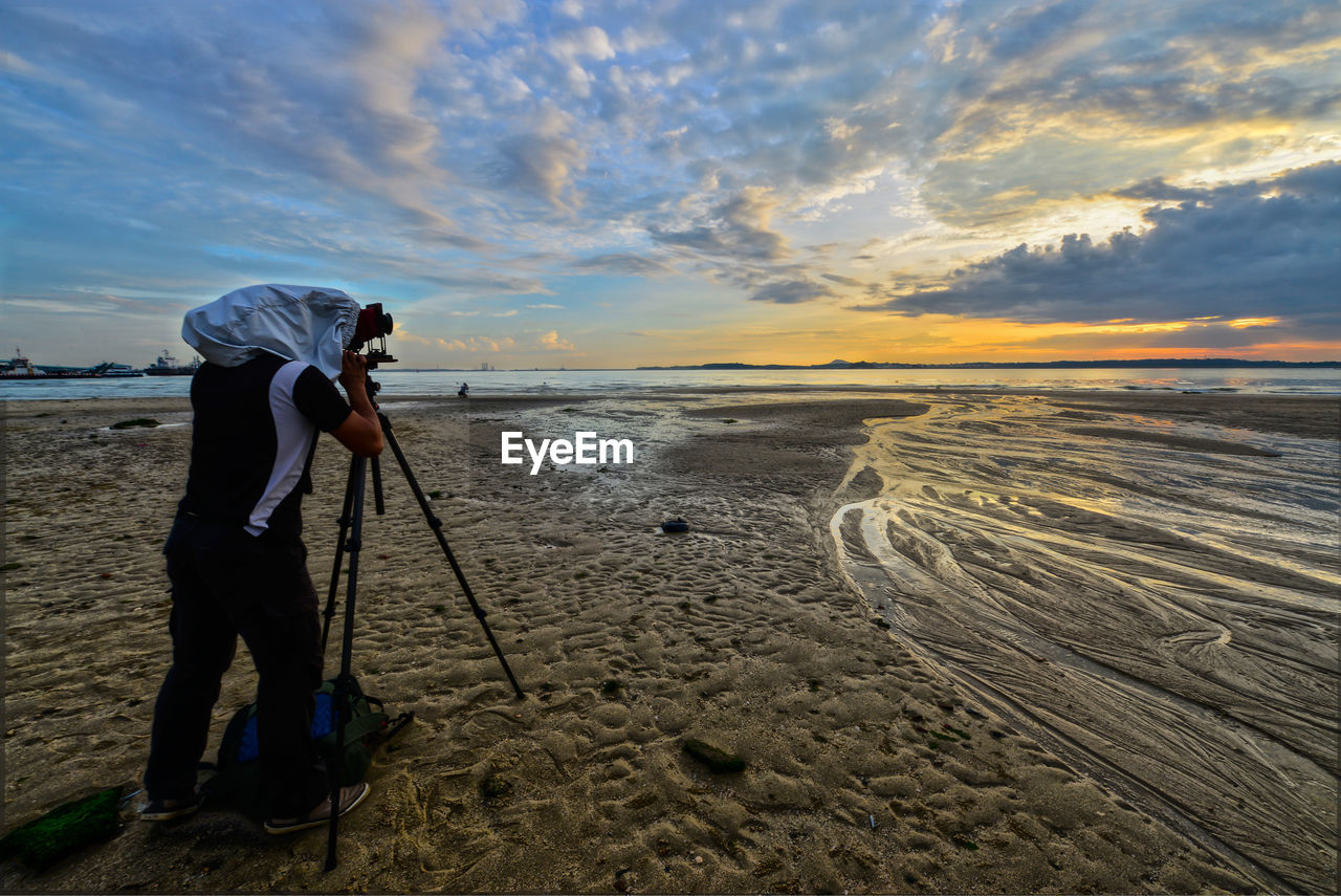 Side view of a photographer at calm beach