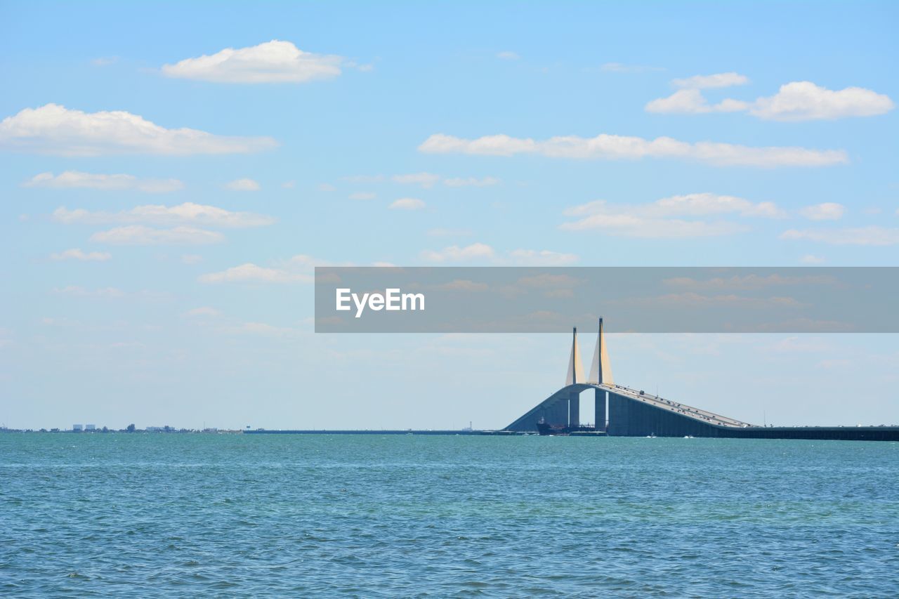 Suspension bridge over sea against sky